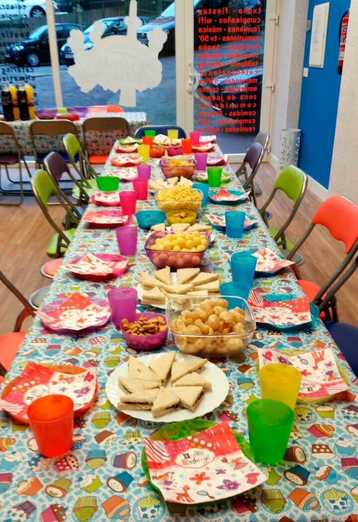 Una mesa larga preparada para una merienda de cumpleaños
