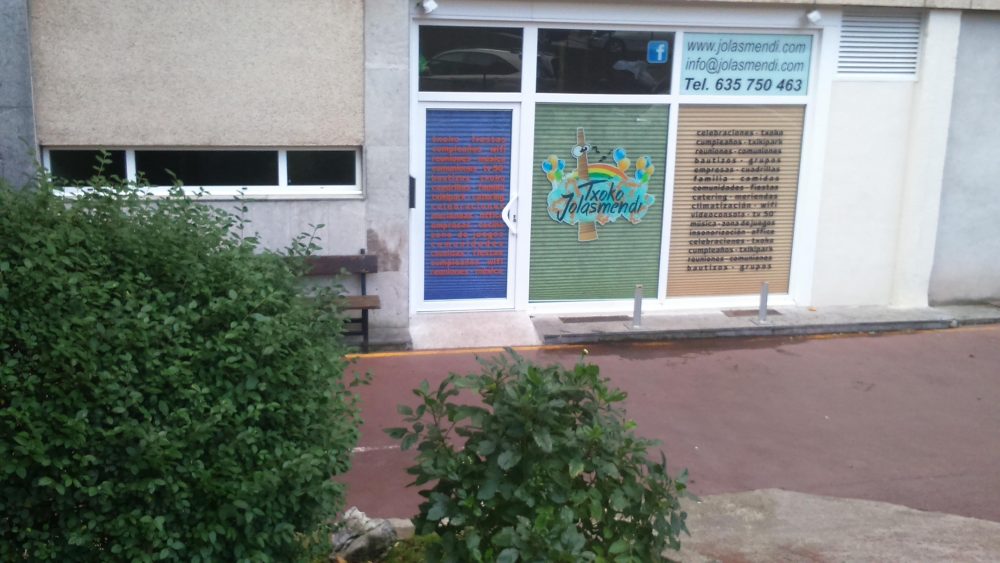 La entrada del txoko, a pie de calle, con la puerta de cristal decorada